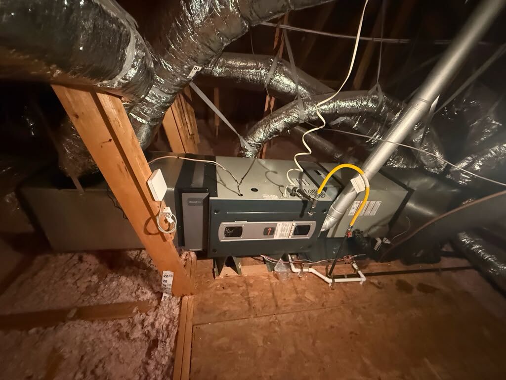 A Trane air handler in an attic with new drain piping and a gas connection.