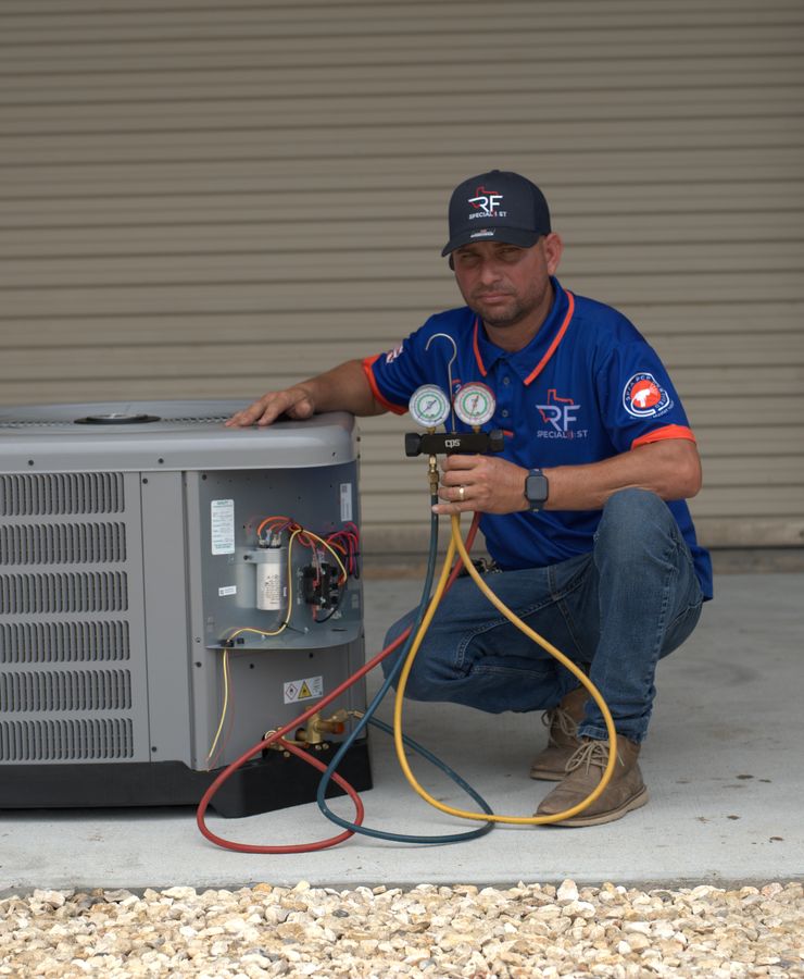 An RF technician checking refrigerant pressures at an outdoor condensing unit.