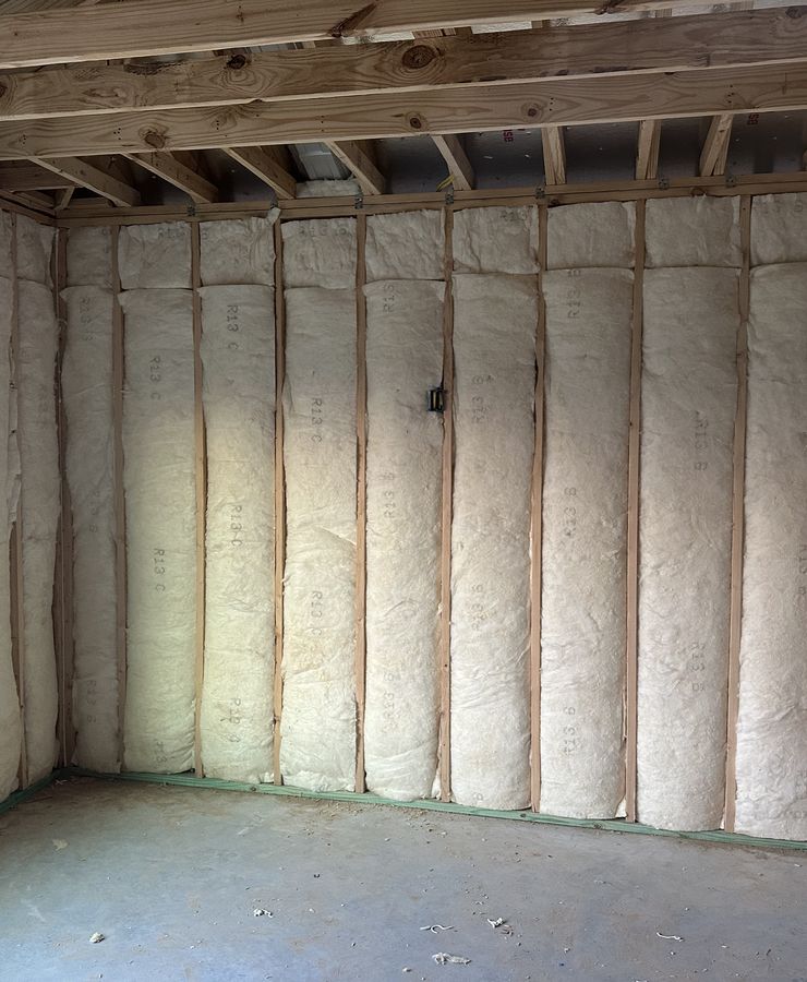 A room's framed walls fully covered with spray foam insulation.