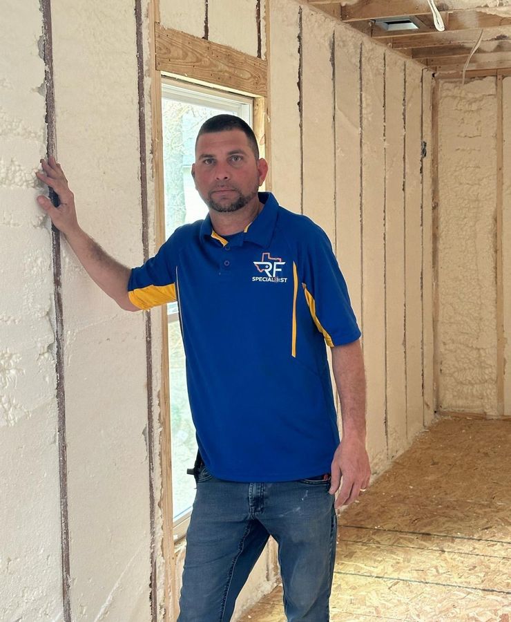 An RF technician standing inside a room insulated with spray foam.